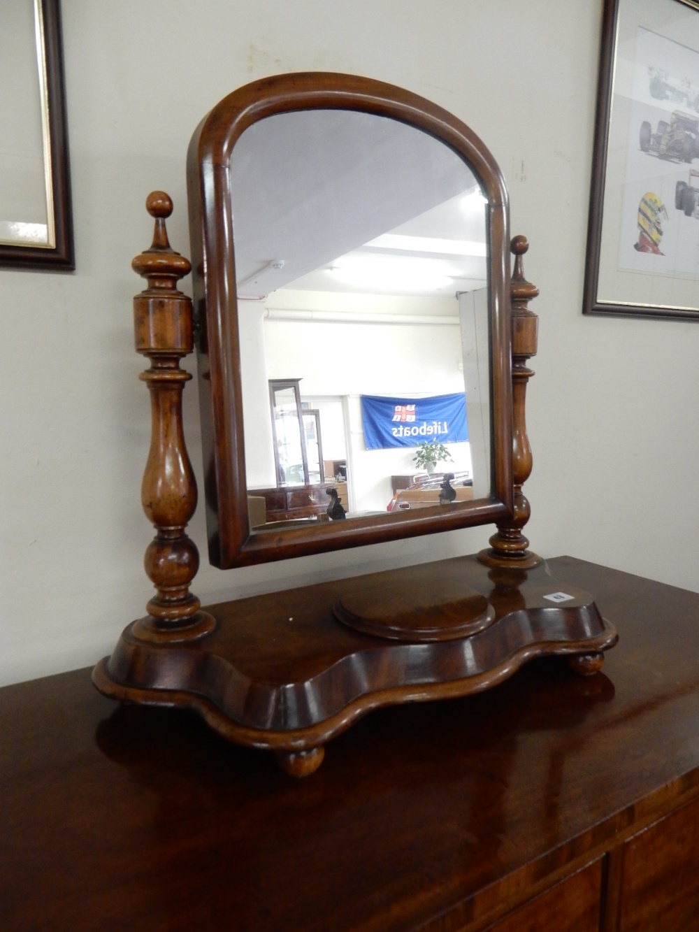 A Victorian mahogany framed swing toilet mirror with arched top, on shaped base with hinged jewel