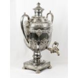 A silver plated double handled trophy cup with embossed decoration, on square base with ball feet (