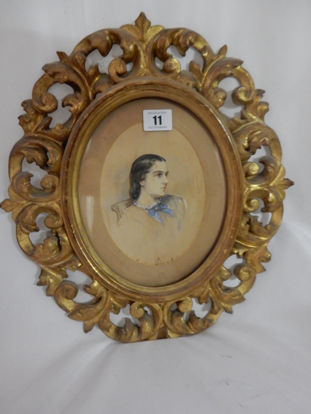 A Victorian watercolour in an oval - Head and shoulders of a girl, in a Florentine frame - 6 1/