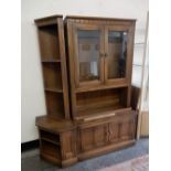 A modern Ercol elm wall unit fitted two glass doors and panelled doors to the base, one end with