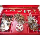 A red leather jewellery box containing a selection of earrings, necklaces, bead necklaces etc..