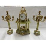 A 19th Century French clock garniture comprising:- clock with circular dial, drum shaped movement