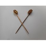 A gold stick pin with horseshoe terminal set seed pearls and fox head and one other stick pin with