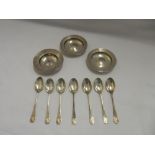 A set of six silver coffee spoons with shell terminals, a glass sugar castor with silver lid and