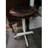 An industrial style white painted metal stool with circular leather seat, on three downswept legs