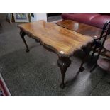 A walnut coffee table with shaped rectangular top, on cabriole legs with claw and ball feet, a