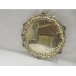 A Walker and Hall silver presentation salver with shell and scroll border, on raised on three