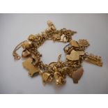 A 9ct. gold bracelet with heart shaped padlock hung with many 9ct. gold charms