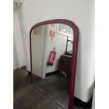 A Victorian overmantel mirror with arched top in a red painted frame