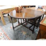 An oak gateleg table fitted two rounded drop flaps, on barley twist legs - 41in. wide