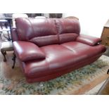 A modern red leather two seater settee on chrome legs