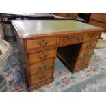 A Victorian mahogany pedestal desk with green and gilt tooled leather top, fitted three frieze