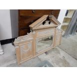 A limed oak overmantel with ached pediment, centre mirrored flanked to each side with panels,