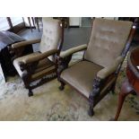 A pair of gentleman's oak framed armchairs with carved finials, upholstered seats and back rails,