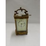 A Victorian carriage clock retailed by T Fattorini of Paris, cream enamel dial, in a brass and glass