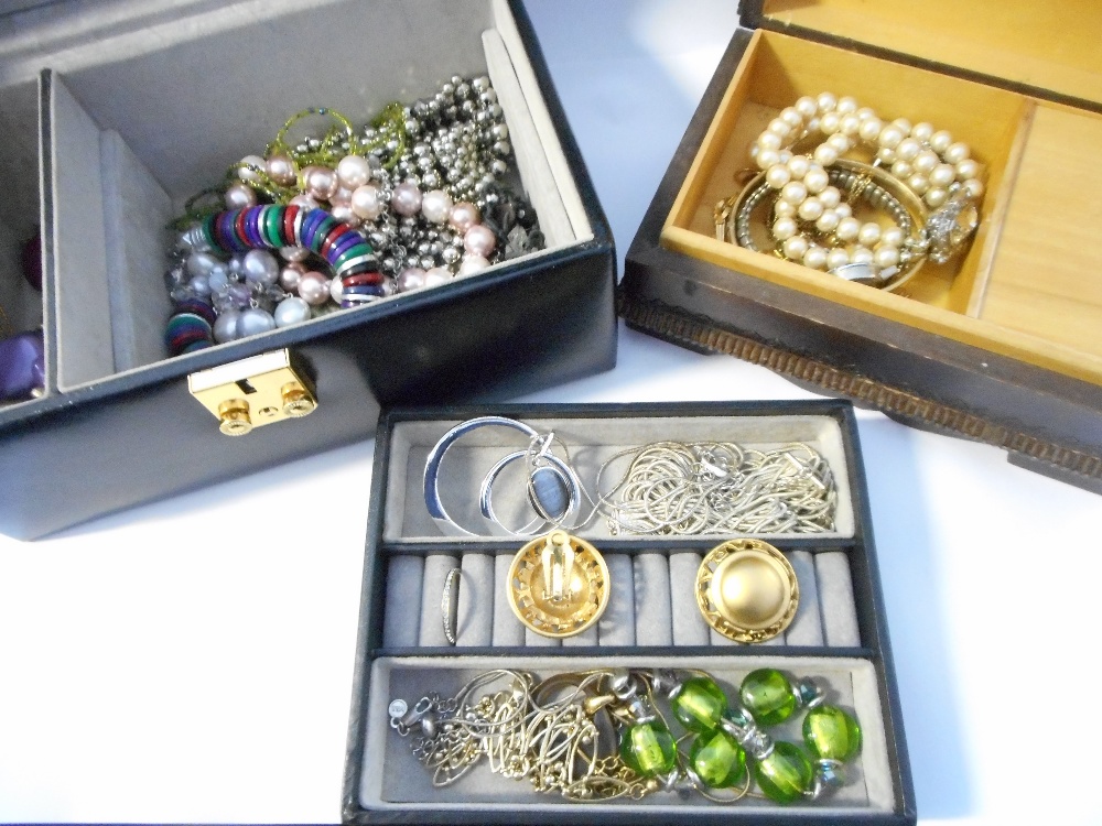 A carved jewellery box containing a rolled gold bangle, simulated pearl necklaces, earrings etc.,