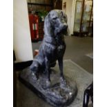 A pair of large black painted cast iron models of seated dogs, on rectangular bases - 36in. high