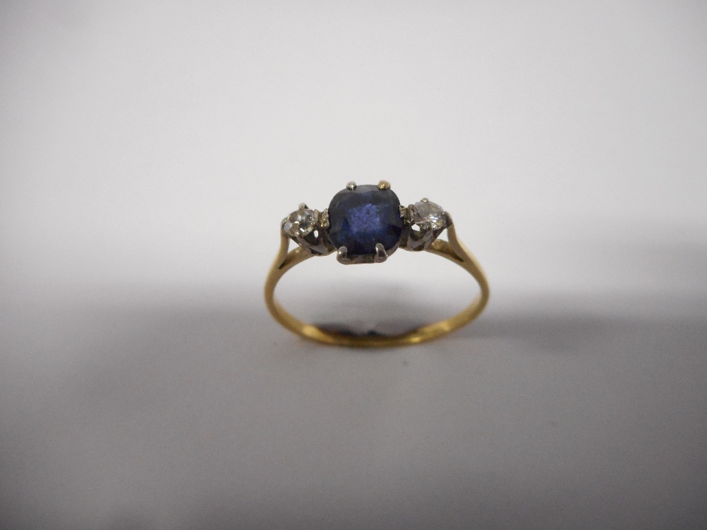 A lady's ring set centre sapphire flanked to each side by two diamonds, on a gold shank, a lady's