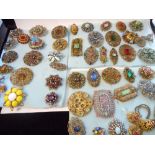 A large collection of coloured paste set brooches