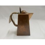 A Newlyn School copper hot water jug of tapering hammered form with wicker covered handle - 7 1/2in.