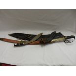 A dress sword with curved blade, in red fabric scabbard, a Kukri knife in scabbard, small knives