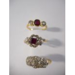 A lady's ring set square ruby flanked to each side by illusion set diamonds, on an 18ct. gold and