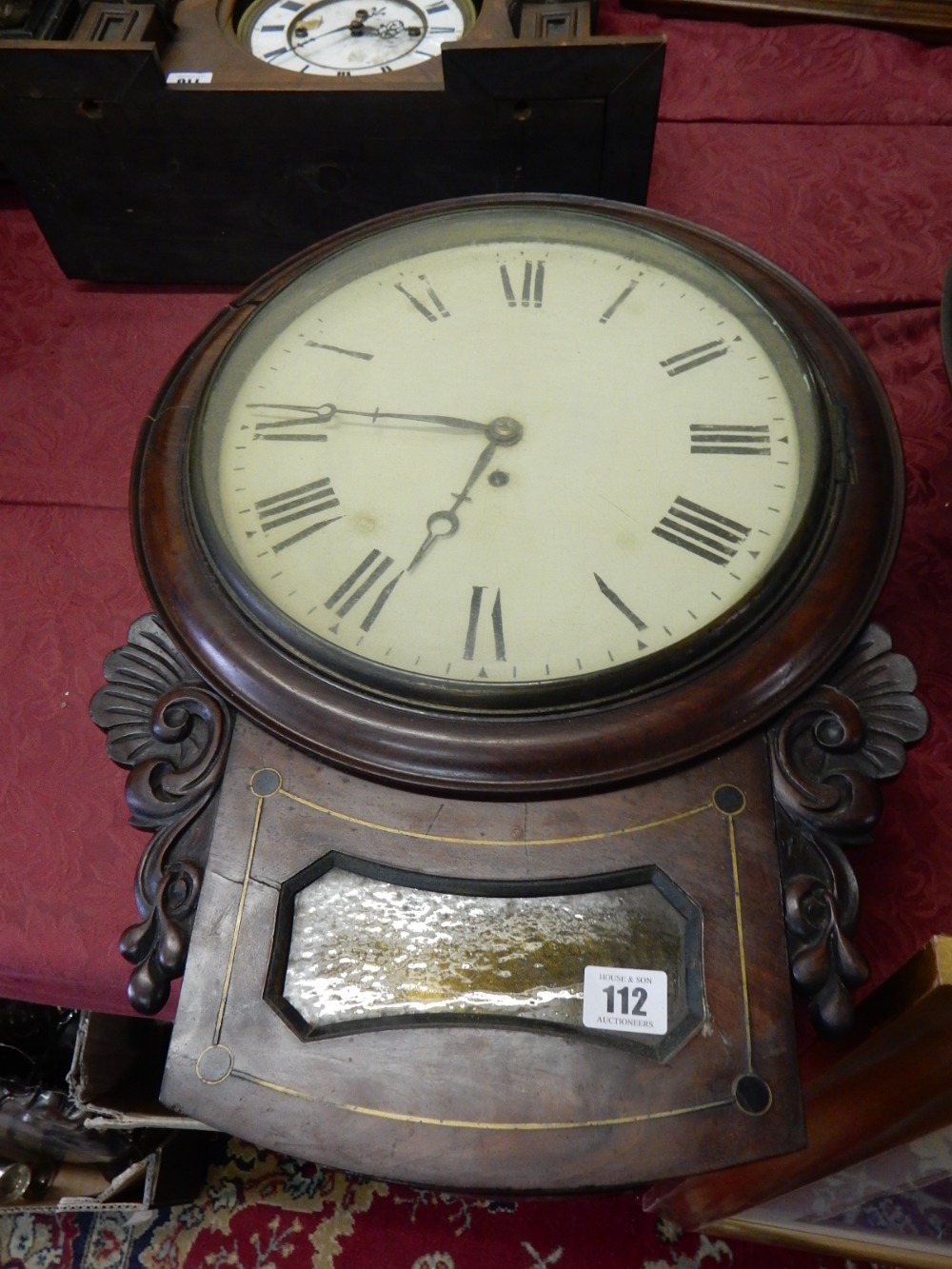 A 19th Century wall clock with cream enamel dial, in a mahogany and brass inlaid case - 21in. long