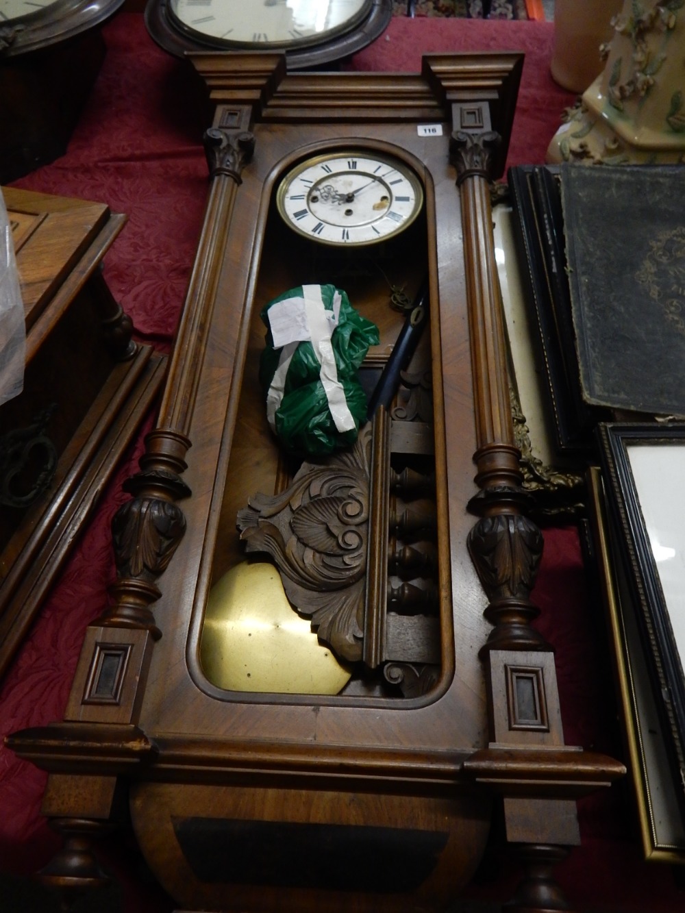 A wall clock with white enamel dial, triple weight movement, in a walnut case with fluted and leaf