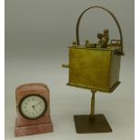 A musical brass box with monkey and a small pink quartz clock,