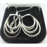 A silver pendant and chain and a pair of silver earrings,