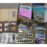 A box of postcards and a box of black and white photographs, souvenir postcard albums, etc.