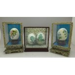 Four Chinese decorated eggs in three display cases