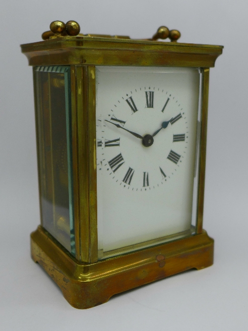 A brass carriage clock, the top bears inscription, From "The Queen's" Regt.