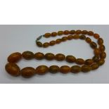 A set of amber coloured beads, 65.