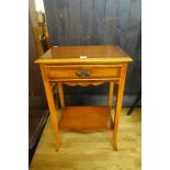 A yew wood single drawer side table