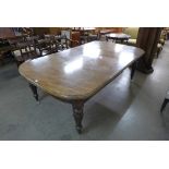 A Victorian mahogany extending dining table with four leaves and leaf cabinet