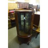 A walnut bow front display cabinet on ball and claw feet