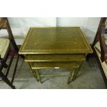 A Regency style brass and green leather nest of tables