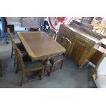 An oak dining suite on carved pineapple legs, comprising a draw-leaf table,