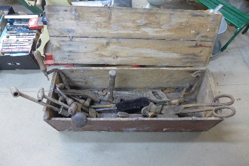 A pine banana crate with assorted tools