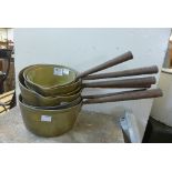 Six brass saucepans