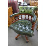 A mahogany and green leather swivel office chair