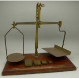 A set of postal scales on a wooden base with four square weights marked GPO