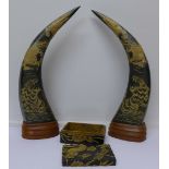 A pair of carved and mounted horns decorated with tigers and dragons and a metal box overlaid with