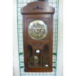 An oak wall clock and a mahogany wall clock