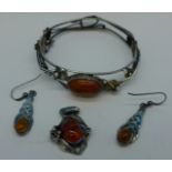 A silver and amber bangle and matching pendant and a pair of silver and amber earrings