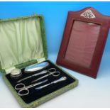 A cased silver manicure set and a silver mounted photograph frame