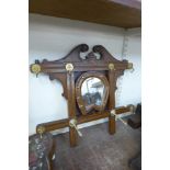 An oak horseshoe shaped hall mirror with coat hooks