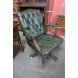 A mahogany and green leather swivel office chair