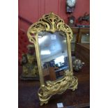 An Art Nouveau style gilt framed toilet mirror